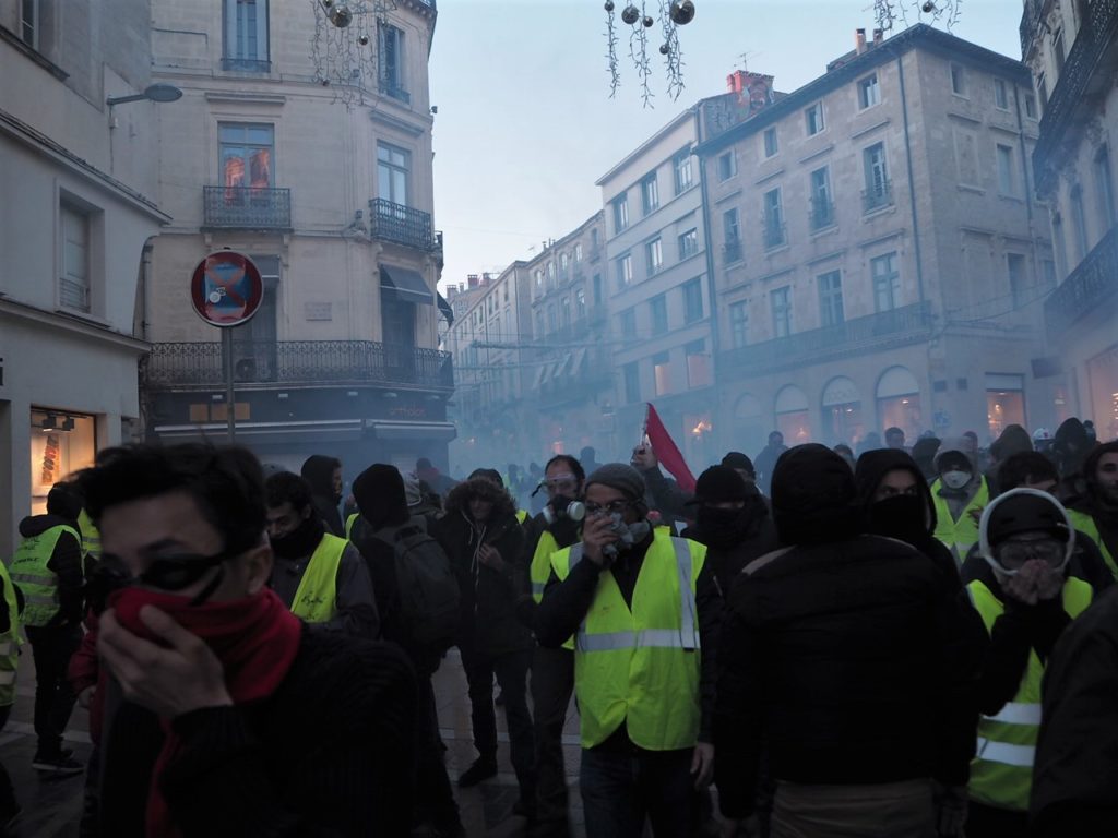 Les gens fuient le gaz lacrymogène dans le centre de Montpellier.
