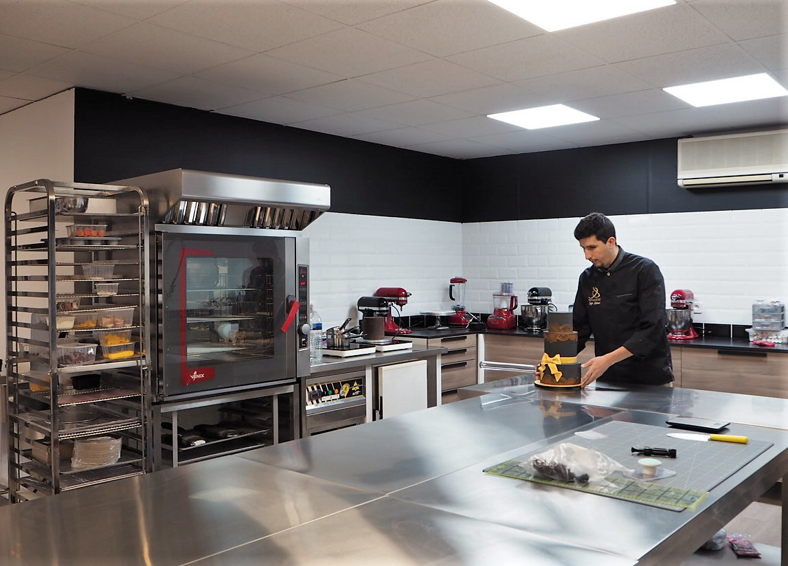 Le cake designer en plein montage d'un gâteau. CP : A.F